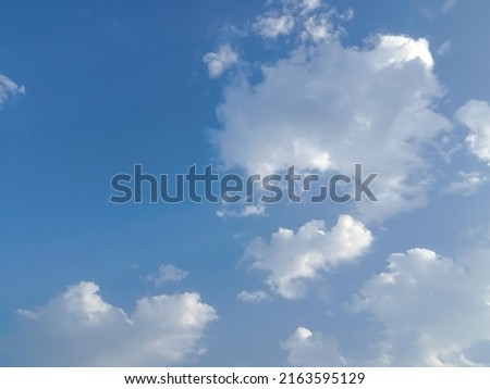 Beautiful white clouds on deep blue sky background. Elegant blue sky picture in daylight. Big glowing soft white fluffy clouds in the blue sky background. Cumulus clouds in clear blue sky. No focus