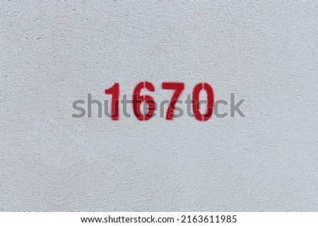 Red Number 1670 on the white wall. Spray paint.

