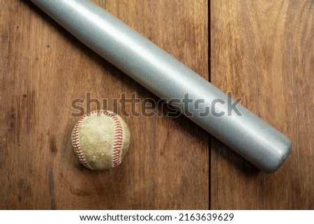 baseball ball and baseball bat isolated on wooden background.