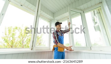 Professional master at repair and installation of windows, changes rubber seal gasket in pvc windows Royalty-Free Stock Photo #2163645289