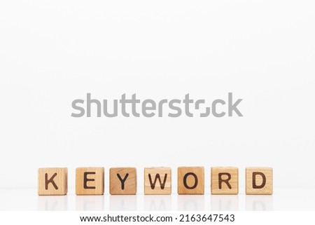 Keyword word is written on wooden cubes on a white background. Closeup of wooden elements