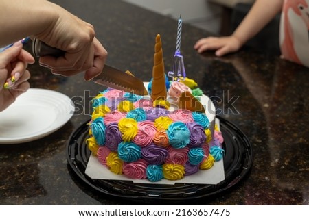 female hand cutting a birthday cake