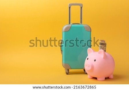 Travel.Vacation money saving concept,piggy bank beach vacation.Miniature luggage and bundles of hundred dollar bills.Vacations.Copy space.Savings concept for vacation. Royalty-Free Stock Photo #2163672865