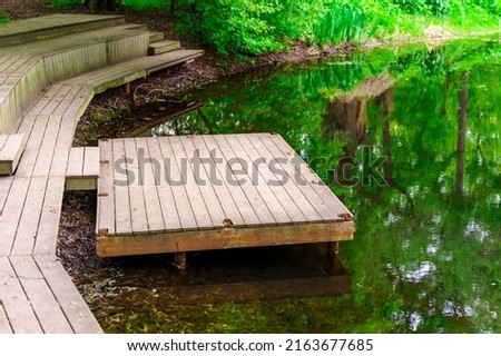 Old wooden pier on an abandoned pond.