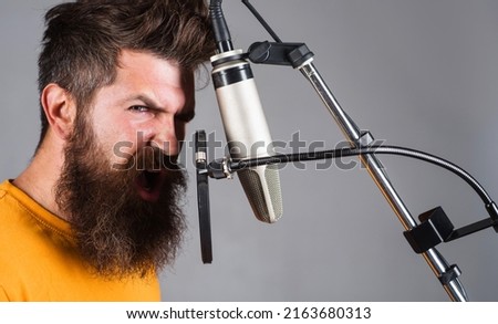 Studio records. Bearded man singing in condenser microphone. Professional vocalist. Karaoke singer.