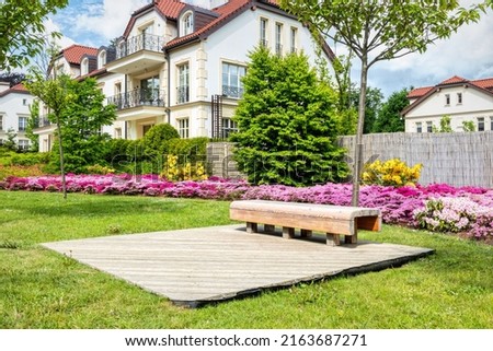 Wooden garden bench in fresh green spring park	