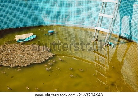 Green yellow water in swimming pool, problem service concept. Dirty abandoned pool Royalty-Free Stock Photo #2163704643
