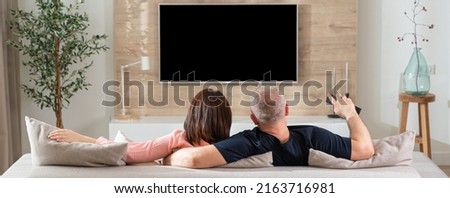 back view horizontal panorama of a couple lying on a sofa in the living room Royalty-Free Stock Photo #2163716981