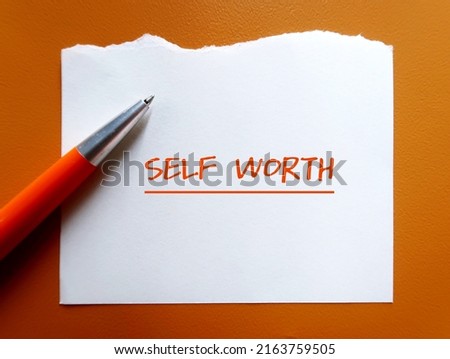 Torn paper on orange background with handwritten text SELF WORTH, refers to self-love, being confidence with self-esteem - giving yourself respect, dignity and understanding Royalty-Free Stock Photo #2163759505