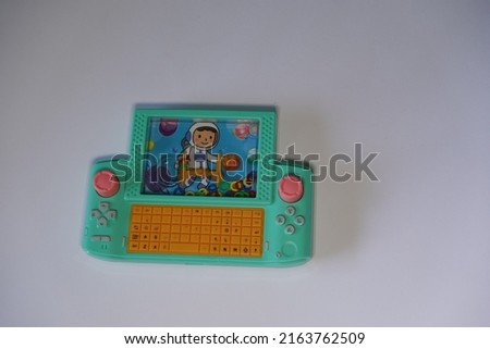 Isolated White Traditional Indonesian children's toy in the form of a green game watch