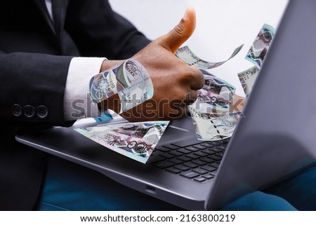 Barbados dollar notes coming out of laptop with Business man giving thumbs up, Financial concept. Make money on the Internet, working with a laptop, Barbadian dollar