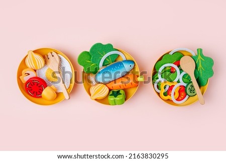 Plates with breakfast, lunch and dinner. Wooden fruit and vegetables play set.  Game for learning and development of the child. Cute wooden kids toys to play in the kitchen Royalty-Free Stock Photo #2163830295