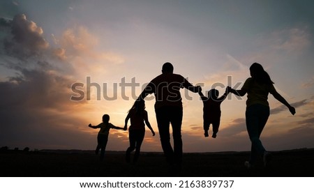 happy family. parent a baby together run in the park at sunset silhouette. people in the park concept. mom dad daughter and son joyful run. happy family and baby child summer kid dream concept fun