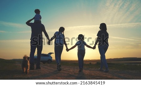 people in the park. happy family a silhouette walk at sunset. car travel kid dream concept sun. happy family parents and fun children walk silhouette next to car. family walk next to car