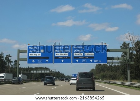 road sign on the motorway and the place in german language as munich City or nuremberg and more cars