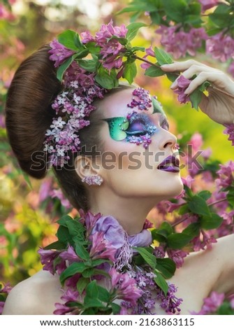 Beautiful young tender girl with a bouquet of flowers. Charming young lady with a bouquet of lilacs. Lilac. Beautiful graduate in lilac Royalty-Free Stock Photo #2163863115