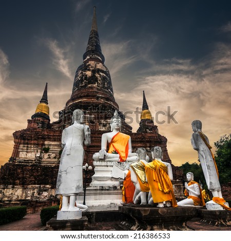 Asian religious architecture. Ancient sandstone sculpture of praying Buddhas at Wat Yai Chai Mongkhon temple under sunset sky. Ayutthaya, Thailand