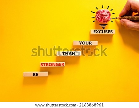 Be stronger symbol. Concept words Be stronger than your excuses on wooden blocks on a beautiful yellow table yellow background. Businessman hand. Business motivational and be stronger concept.
