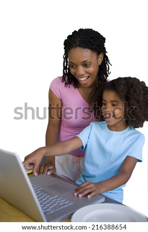 Girl with mother pointing to screen of laptop computer, smiling, cut out