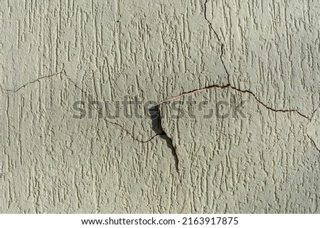 Peeling paint of a house wall. Wall with cracks on the wall paint, brazilian grafiato texture.