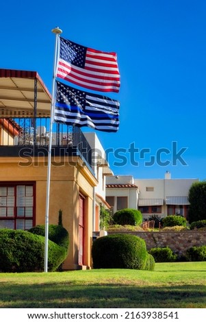 The morning sun warms the American and Thin Blue Line flags flying proudly in the Manhattan Heights Historic District of El Paso, Texas.