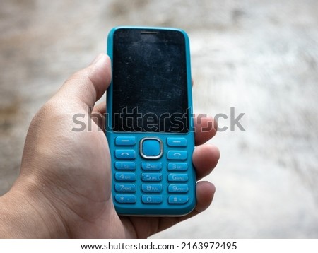 man's hand holding cell phone with black blank screen