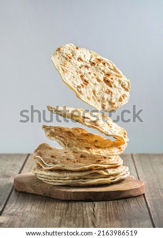 Indian chapati flatbread, creative photography with levitation. High quality photo Royalty-Free Stock Photo #2163986519