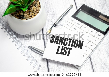 SANCTION LIST Written words on paper notebook . workplace. Business concept.