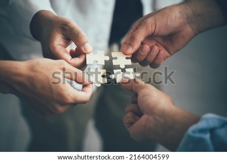 Concept of teamwork and partnership. Hands join puzzle pieces in the office. business people putting the jigsaws team together.Charity, volunteer. Unity, team business. Royalty-Free Stock Photo #2164004599