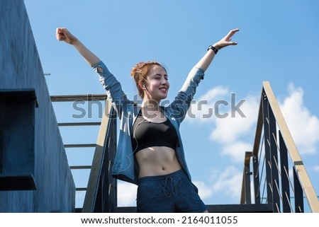 Young woman exercising on urban buildings on a sunny summer day - stock photo