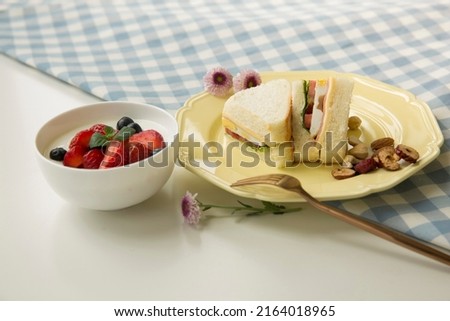Creative image. Strawberries, blueberries, berries, flavored yogurt, fast food sandwich, family, restaurant, breakfast - stock photo