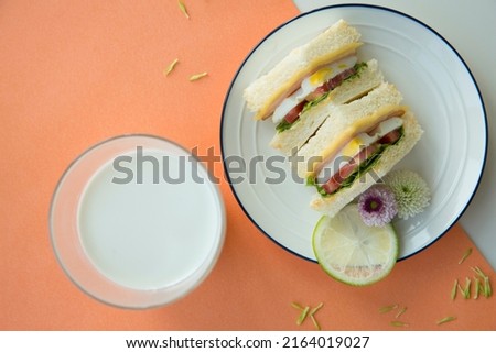 Creative image. Fried egg sandwiches with hot milk for breakfast - stock photo