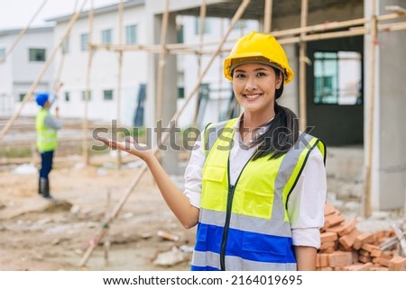 happy woman engineer worker builder girl lady smile present promote gesture at construction site. Royalty-Free Stock Photo #2164019695