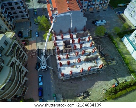 Bird's eye view of diligent construction of large multi-storey resort apartments in residential area with empty streets and trendy cars near sea sandy beach of Black Sea in town of Pomorie, Bulgaria