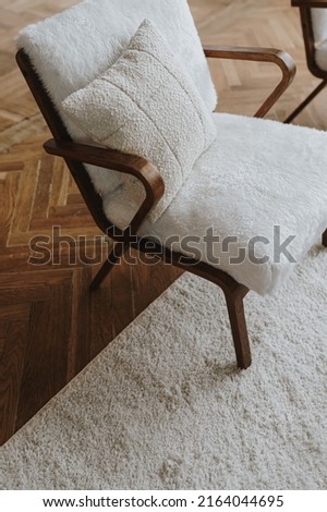 Elegant Scandinavian hygge style home living room interior. Cozy lounge armchair, carpet, wooden parquet floor