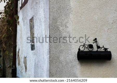 Building wall with a figure of a postman, bike and dog. Selective focus. High quality photo