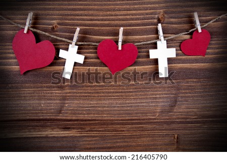 Hearts and Crosses Hanging on a Line on wooden Background