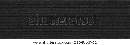 Old black brick wall wide texture. Dark messy gray masonry panorama. Rough brickwork panoramic grunge industrial background