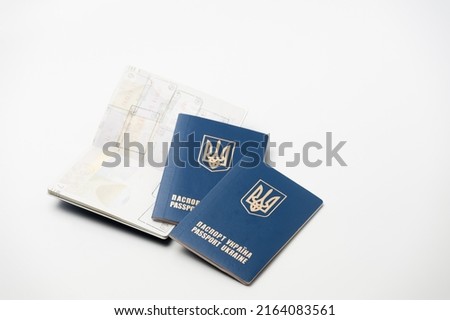 several passports of the citizen of Ukraine with a coat of arms on a wrapper lying on a white background