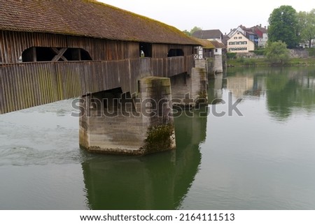 Covered wooden bridge over the Rhine River at Stein, Canton Aargau, and Bad Säckingen, Baden-Württemberg, on a cloudy spring day. Photo taken May 6th, 2022, Stein, Switzerland.