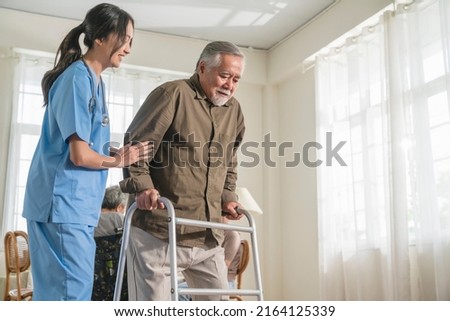 young asian female nurse care giver helping asian senior old man with mobility walker in living area of nursing home senior daycare center,Nurse take care elderly patient with cheerful concentrate Royalty-Free Stock Photo #2164125339