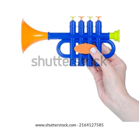 Kids toy musical instrument trumpet in hand on white background isolation