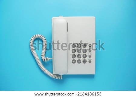 White landline telephone with grey buttons isolated on blue or pastel background Royalty-Free Stock Photo #2164186153