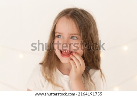 Beautiful little girl, has happy big gray eyes, fun smile, long lashes, thick eyebrows. Child close up portrait. Lifestyle concept. Studio white  isolated. Fashion kid style. Amazing face.