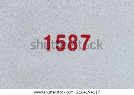 Red Number 1587 on the white wall. Spray paint.
