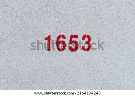 Red Number 1653 on the white wall. Spray paint.
