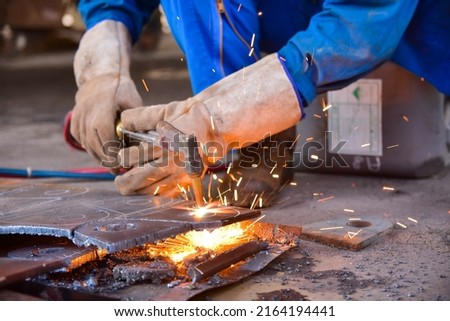 Worker cutting metal steel by Gas Cutting Torch. He cutting the iron plate in the workshop. Royalty-Free Stock Photo #2164194441