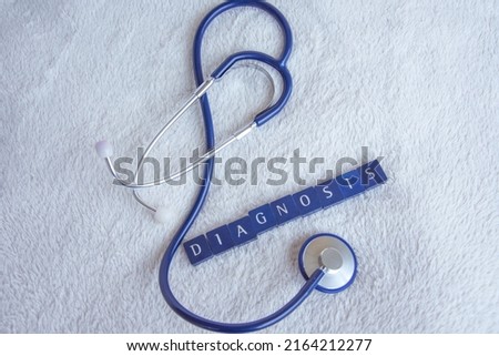 a stehtoscope with the word diagnosis on a white blanket
