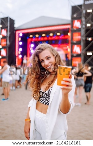 Young woman drinking beer and having fun at music festival.  Beach party, summer holiday, vacation concept.