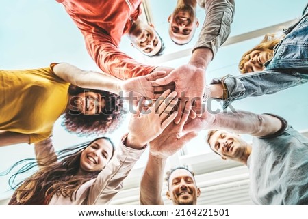 Group of young people stacking hands together outdoor - Community of multiracial international people supporting each other - Union, support and human resources concept Royalty-Free Stock Photo #2164221501